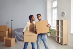 picture of overjoyed couple with cardboard boxes celebrating a move