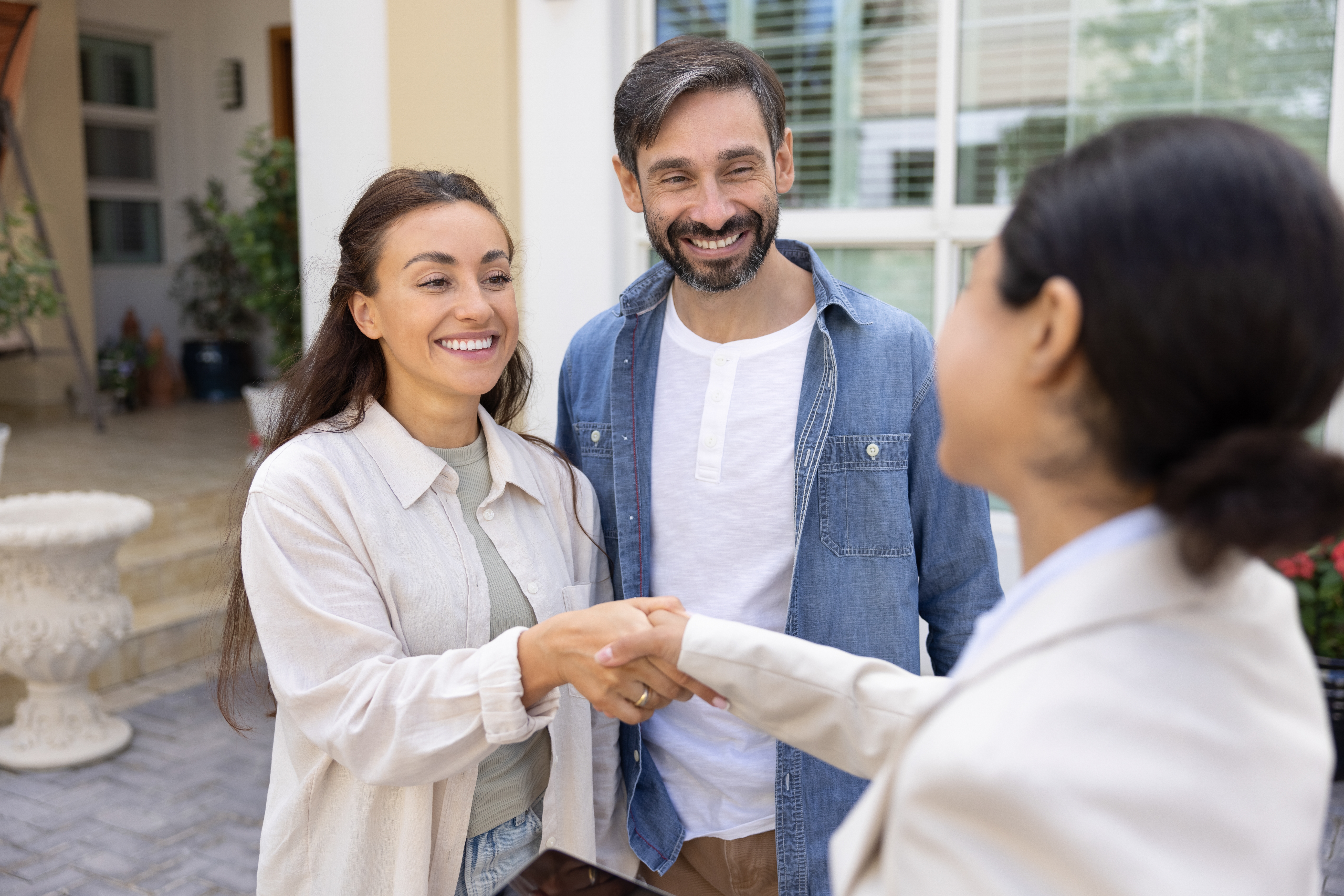 woman greeting couple with a handshake