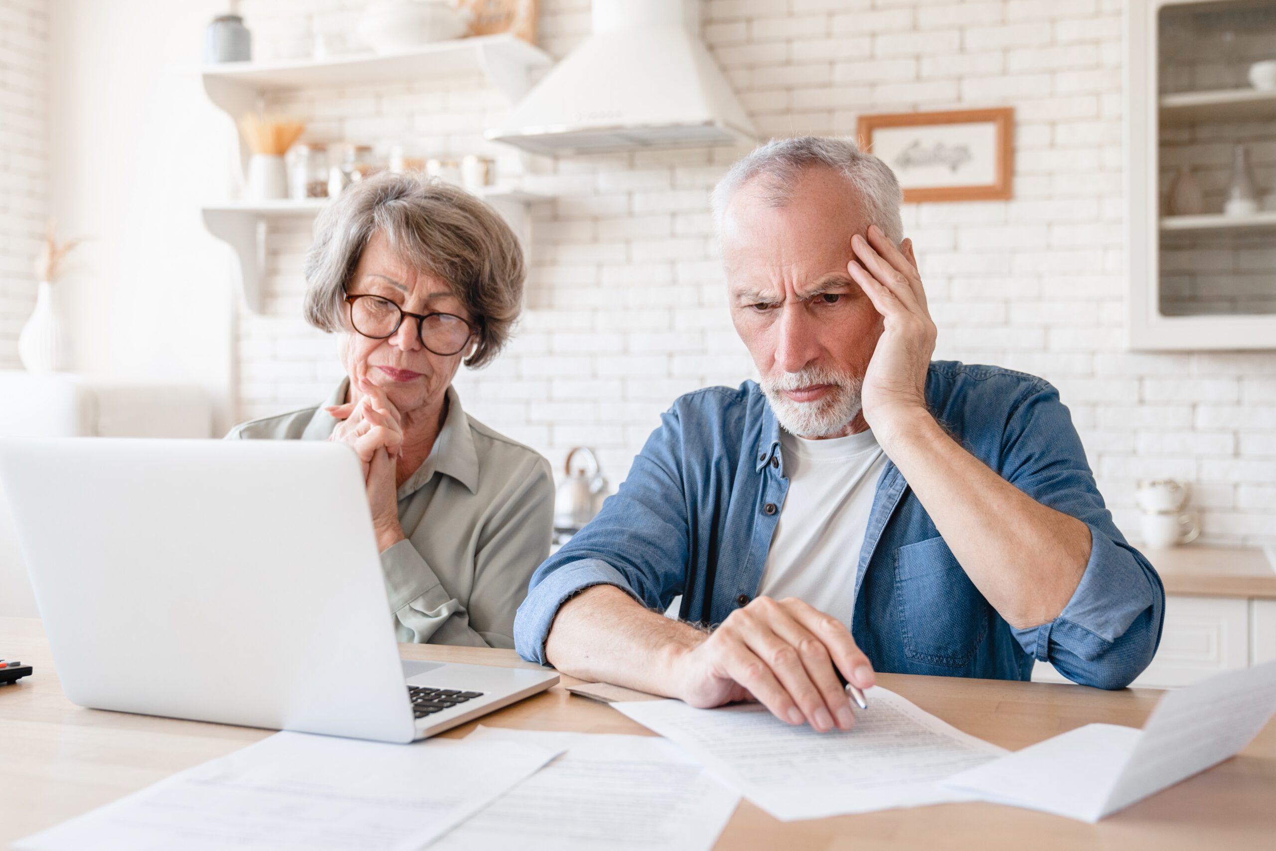 couple on computer looking sad and stressed
