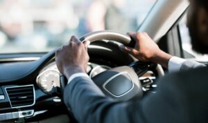 two hands on steering wheel while driving car