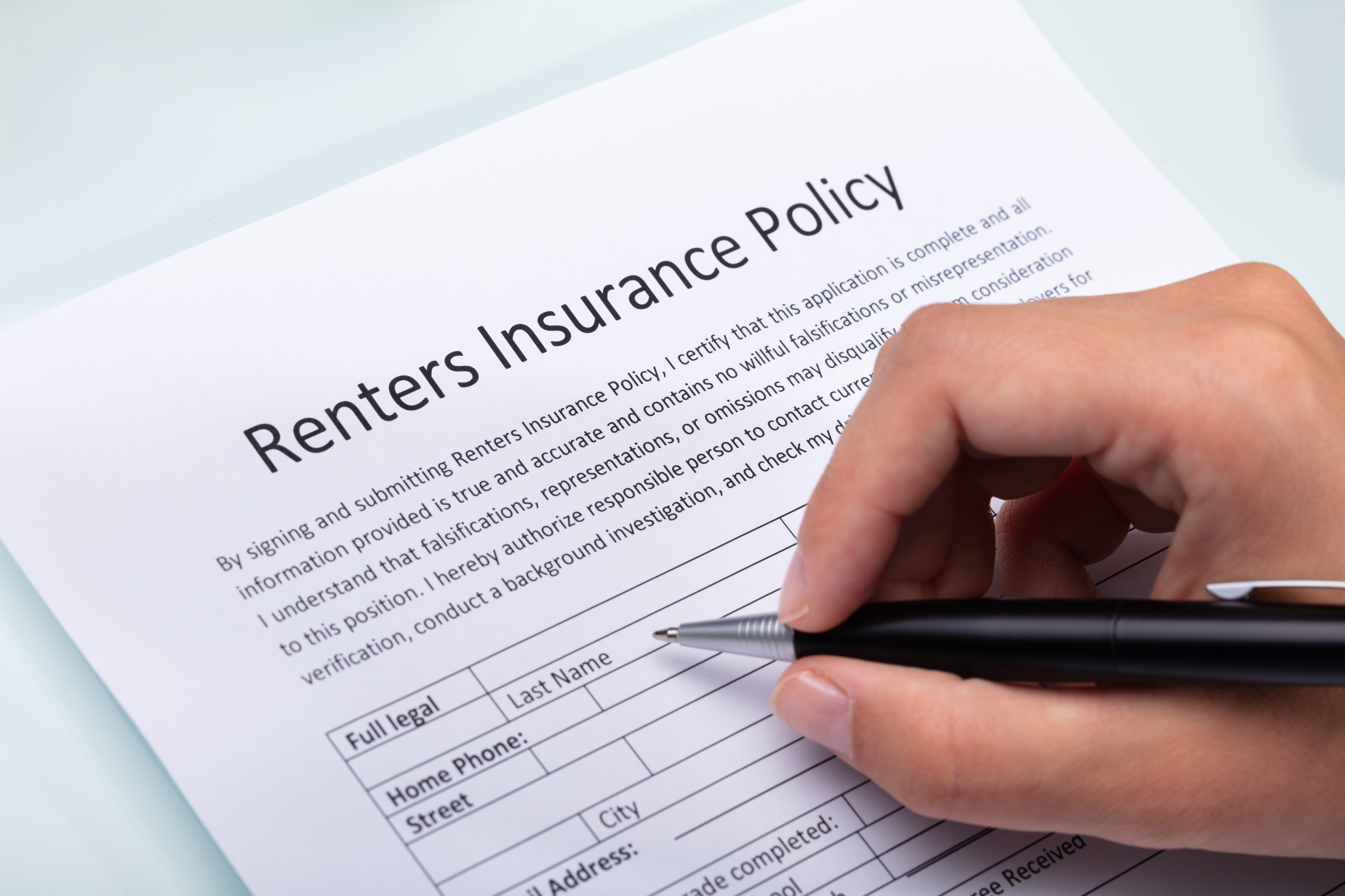close up of a person doing renters insurance paperwork