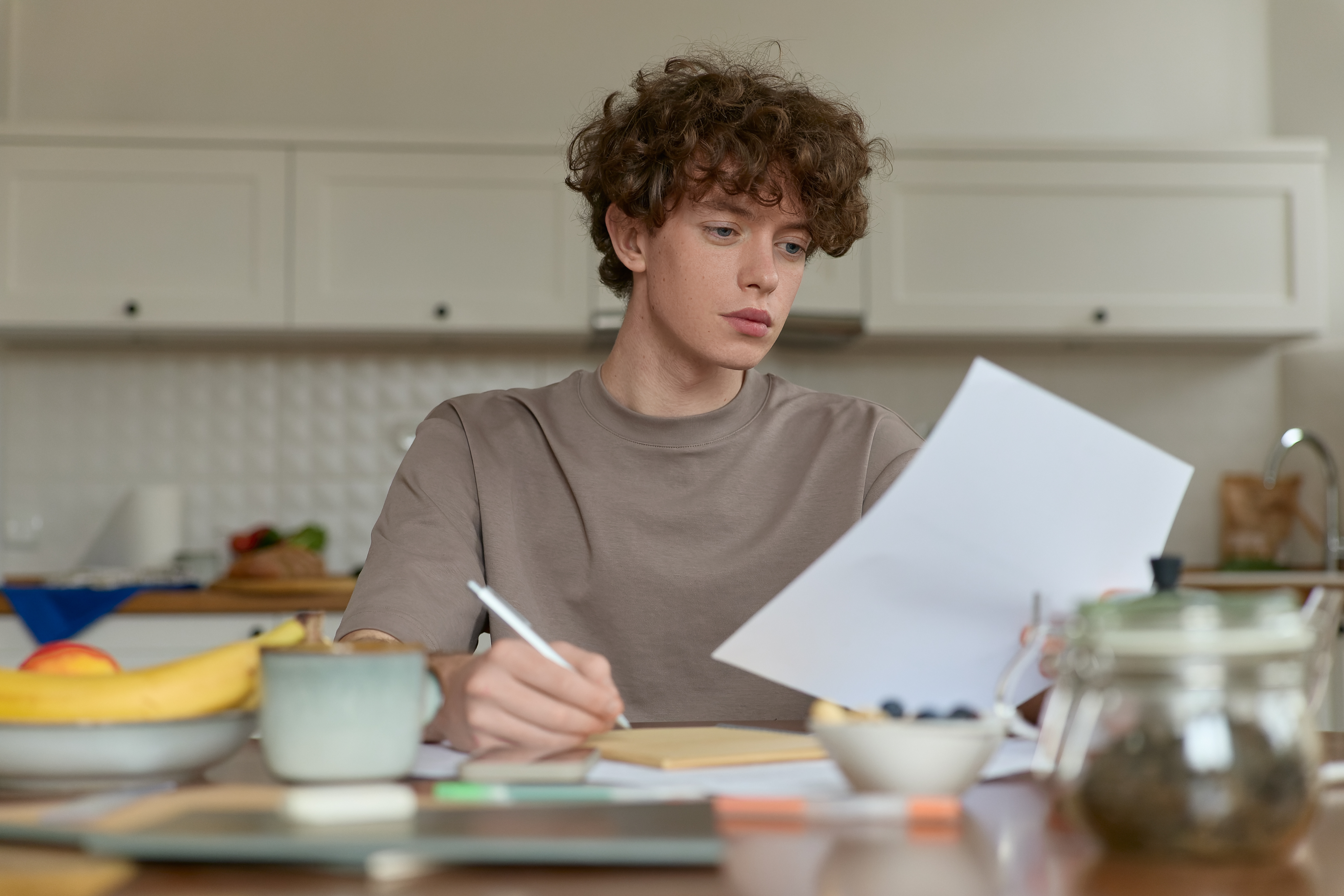 close up of young curly haired male reviewing documents