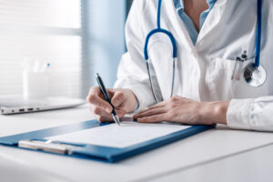 doctor sitting at desk writing a prescription