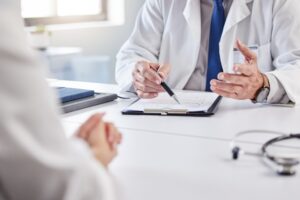 doctor and patient hands with consultation clipboard