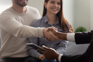 a couple sitting together and shaking hand of someone across from them