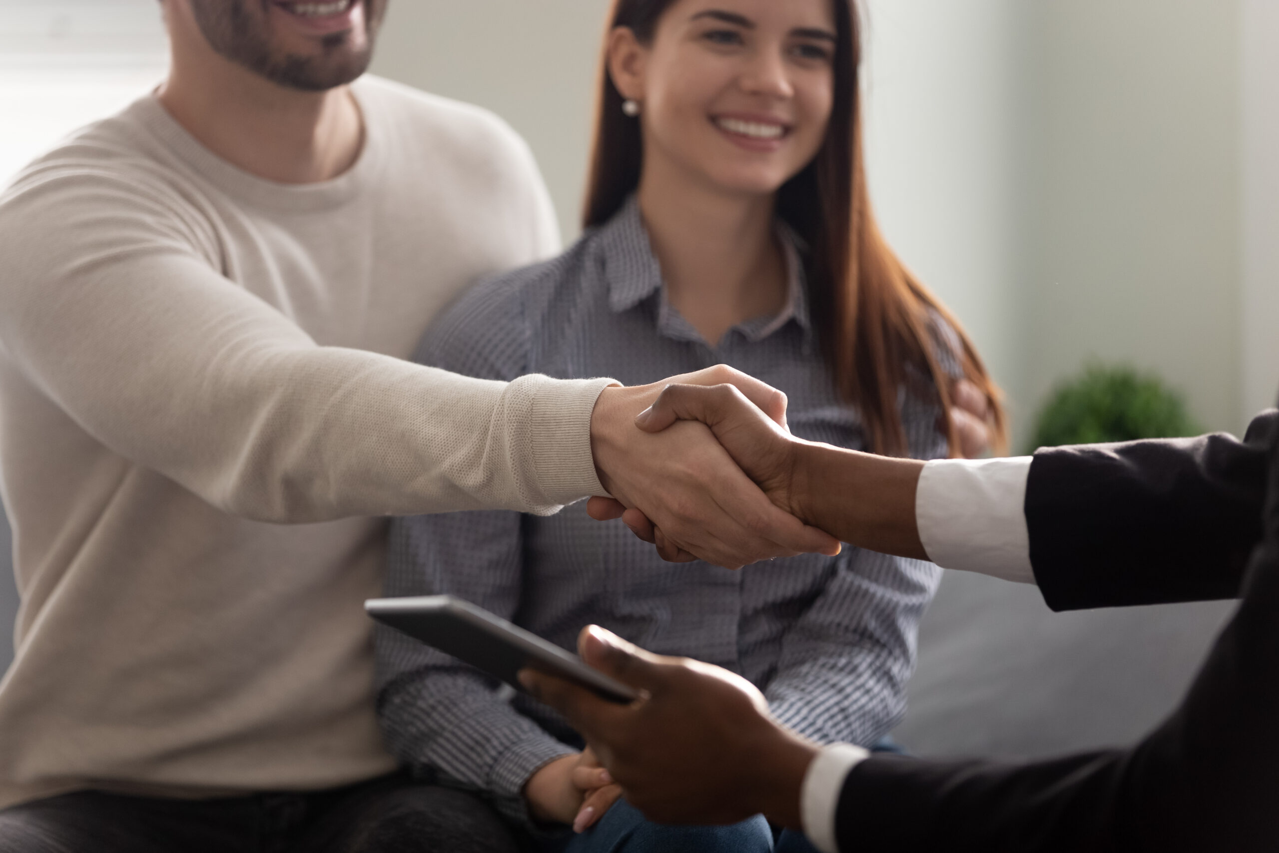 a couple sitting together and shaking hand of someone across from them