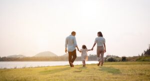 happy family of three in the park at sunset