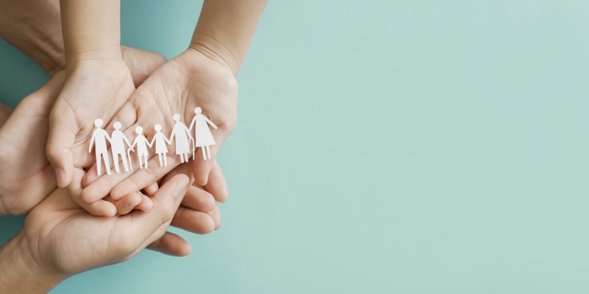 hands holding multi generational paper family