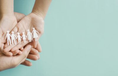 hands holding multi generational paper family