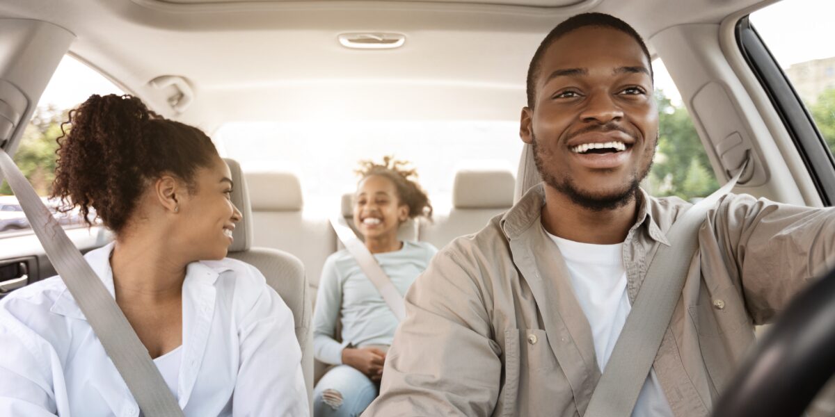 happy family of three riding in car