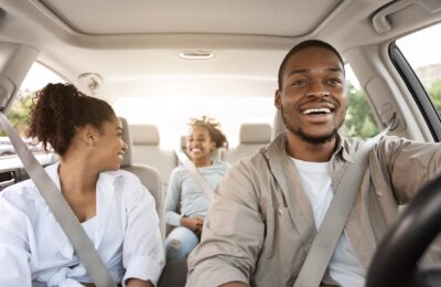 happy family of three riding in car